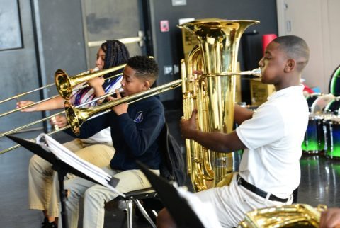 A boy is playing a trombone